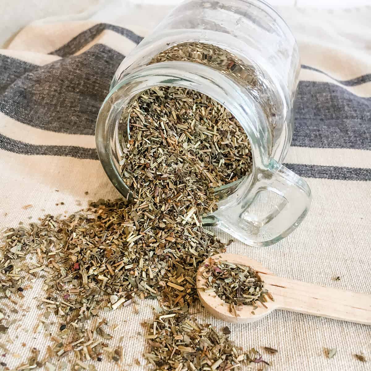 glass jar with herbs de Provence spilling out