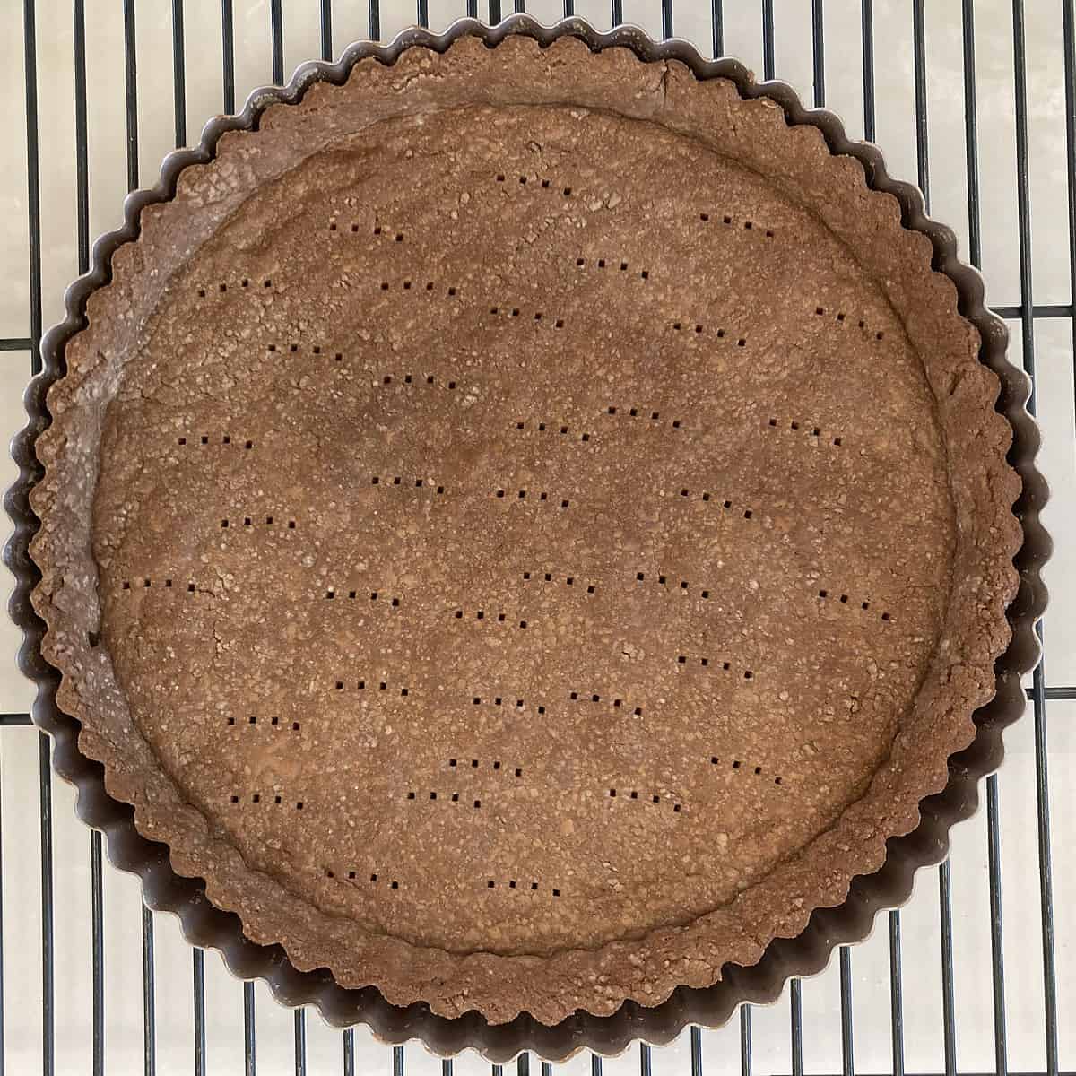 baked chocolate tart crust in pan on cooking rack