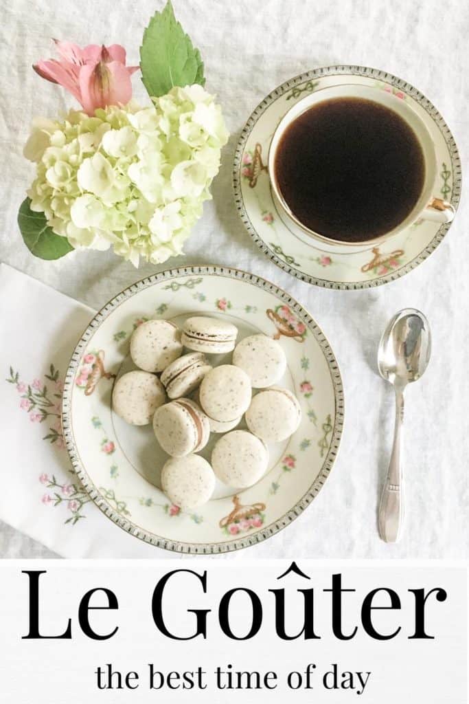 Vanilla macarons on a plate with a cup of coffee and flowers