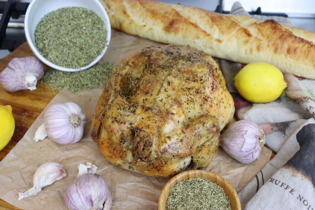 Roasted chicken surrounded by Herbes de Provence, lemon, garlic and a baguette