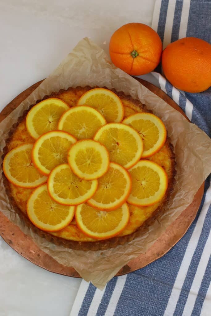 Orange slices arranged in a pattern on top of a tart.