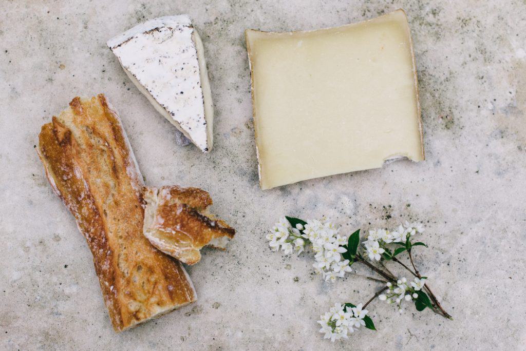 Cheeses on a marble surface with baguette