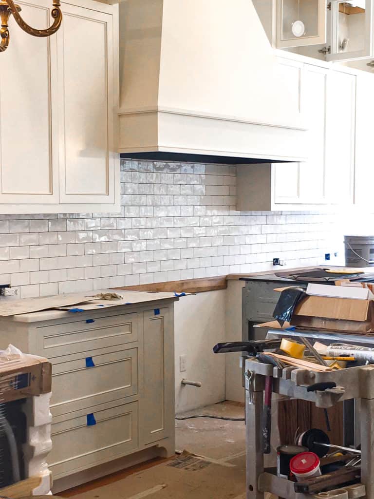 Unfinished kitchen renovation with cabinets and hood