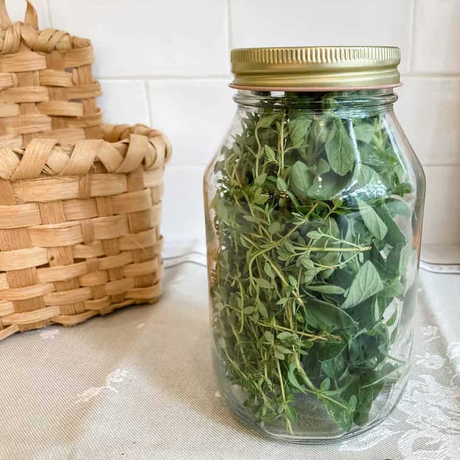 mason jar with lid and fresh herbs inside