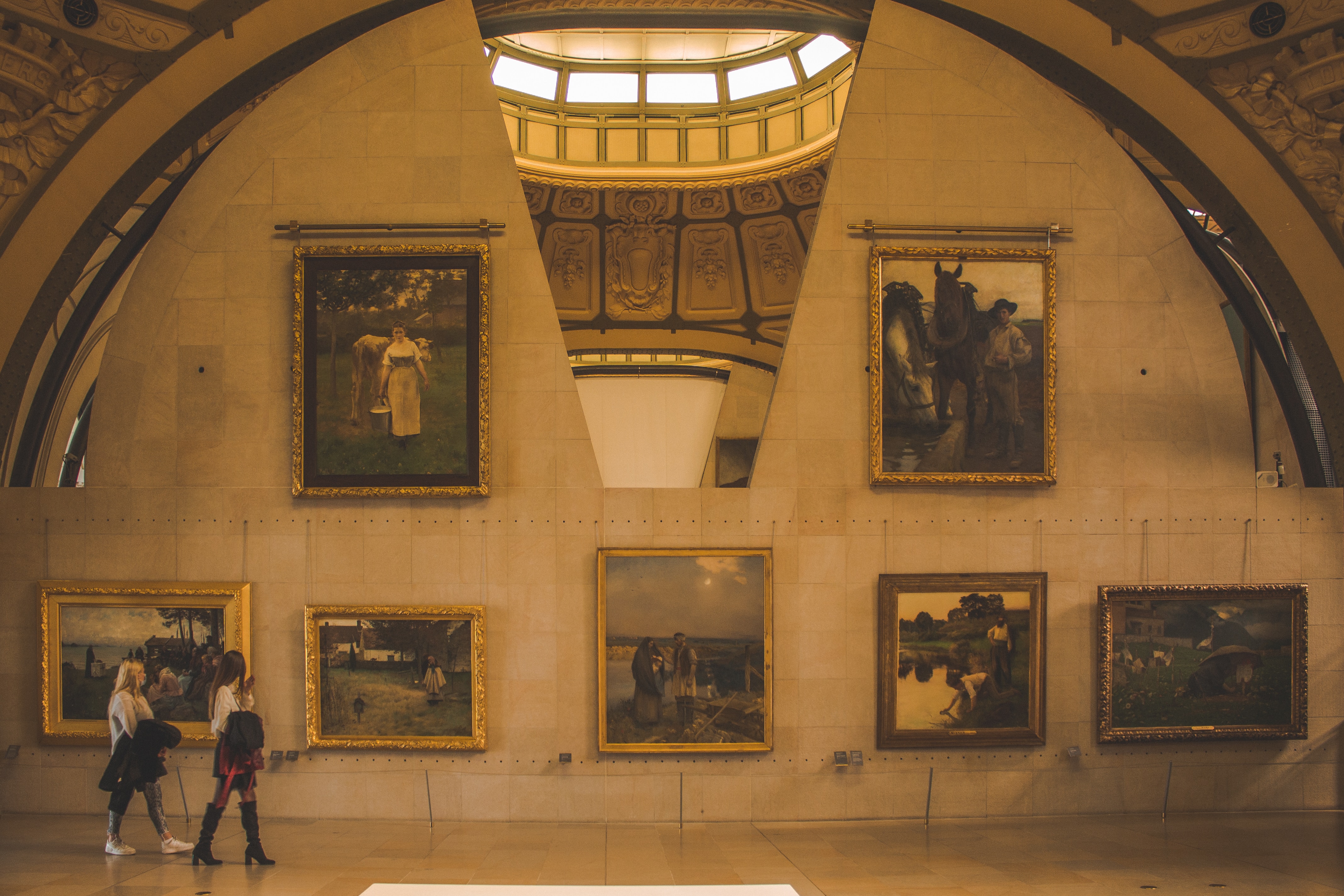 Two women looking at paintings in a museum