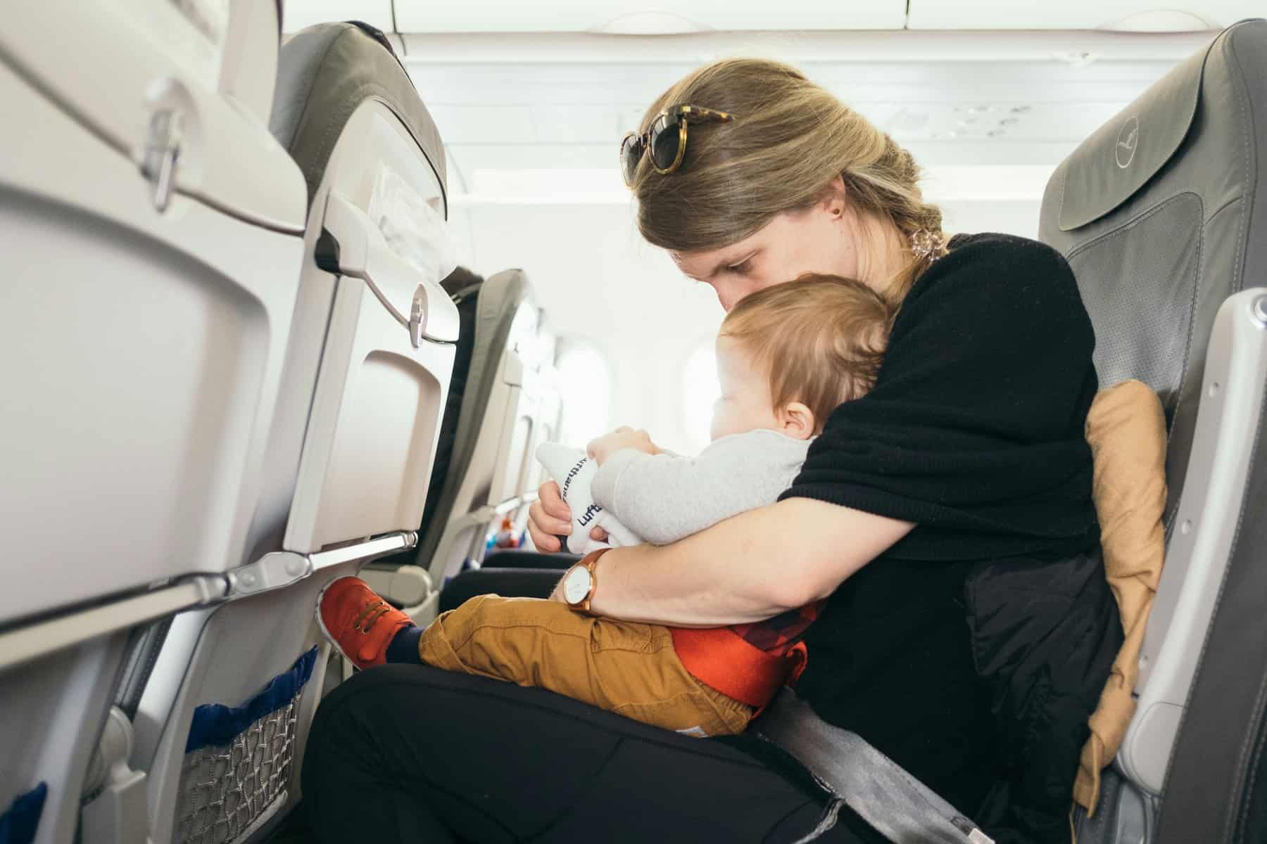 Woman in airplane with baby on lap