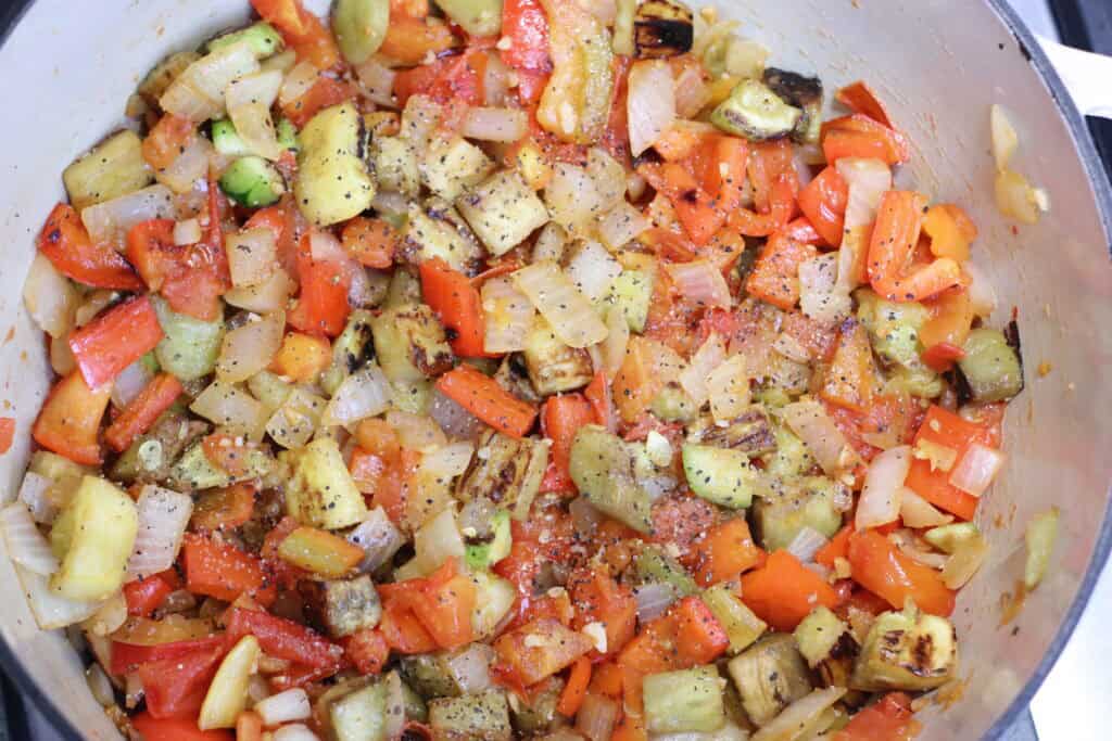 Colorful diced vegetables simmering in a pot.