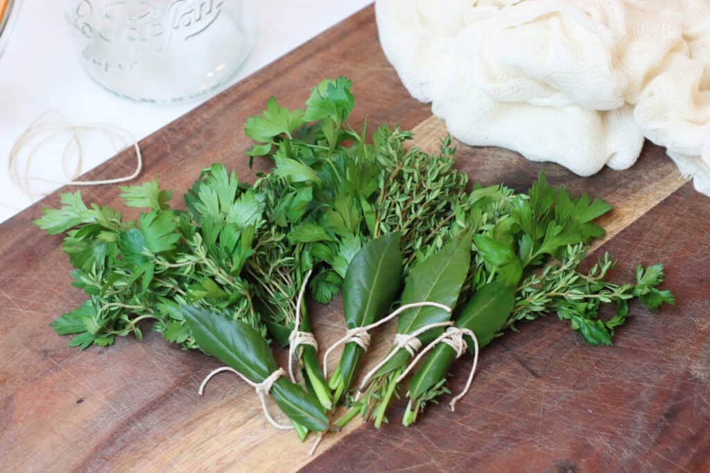 Several bunches of bouquet garnis on a cutting board
