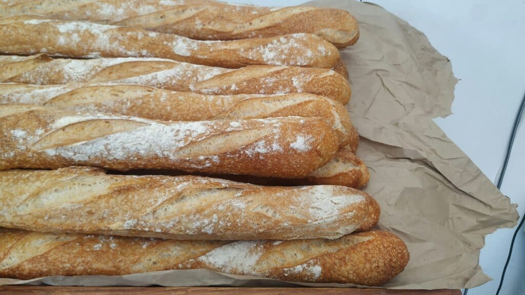 Stack of baguettes lying on a sack cloth.