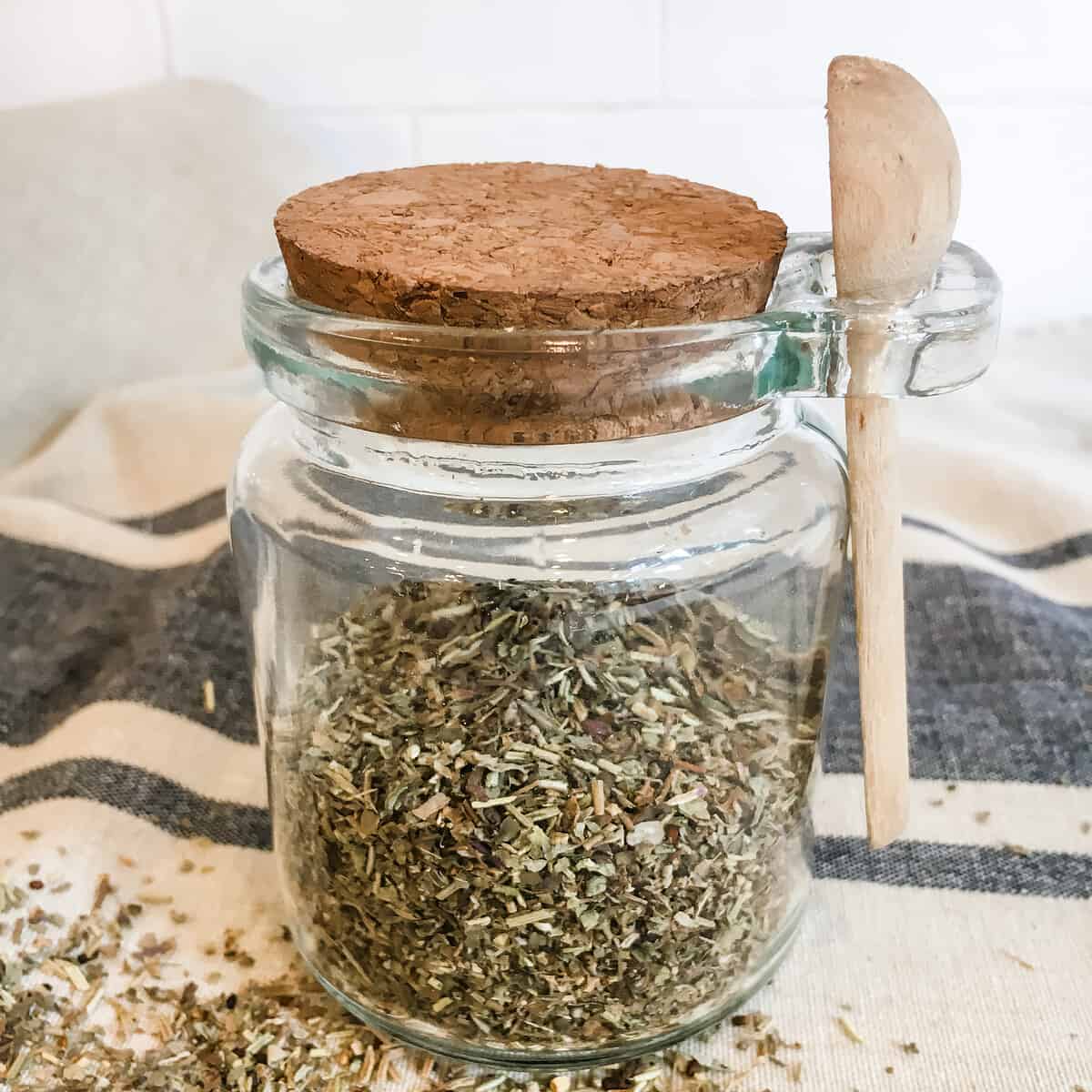 glass jar with cork lid containing herbs de Provence