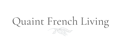 Quaint French Living written out in dark grey letters with a leaf motif underneath.
