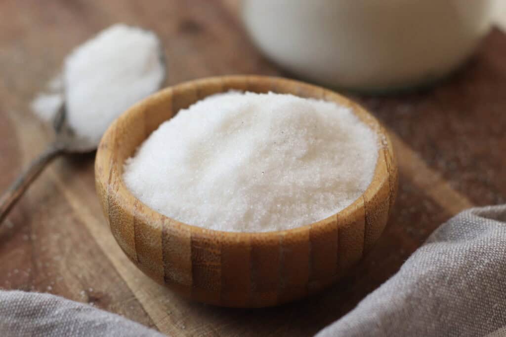 Flavored sea salt in a wooden bowl on rustic wooden background, French culinary ingredient, natural seasoning, gourmet culinary product for home cooking or food presentation.